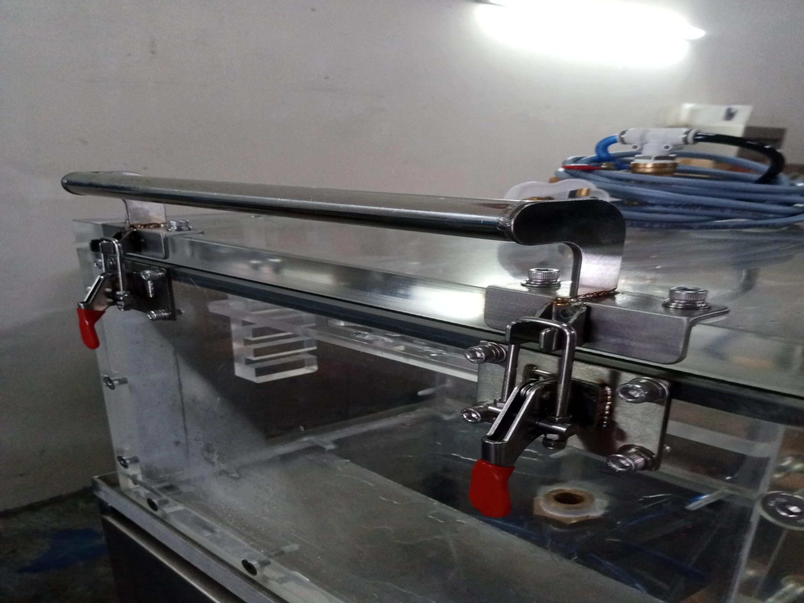 Pure Automation - An automated leak testing machine on a conveyor line, inspecting food packaging with digital sensors and status indicators.